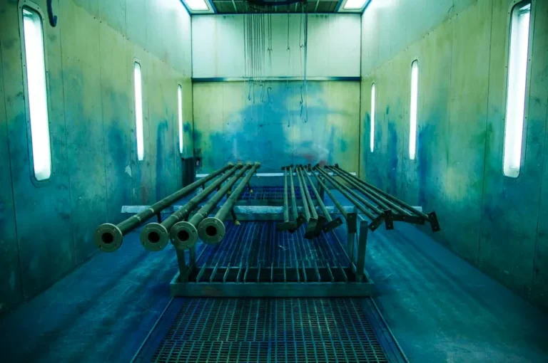interior de la cabina de pintura de afau con unos tubos por pintar