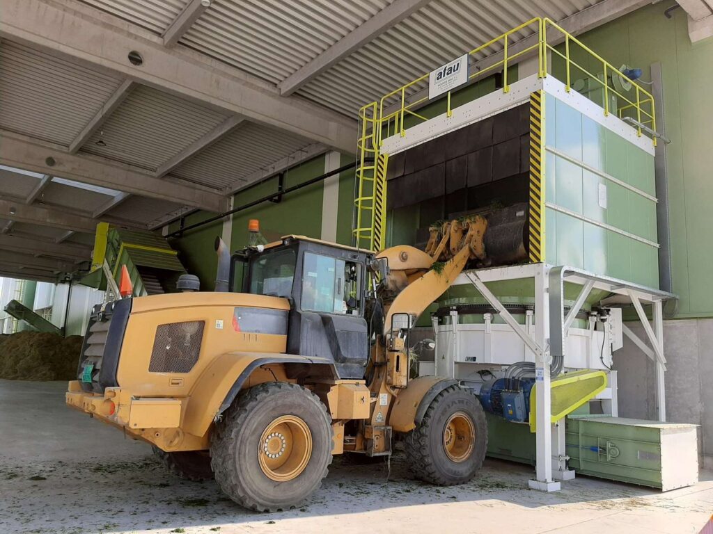 Pala introduciendo alfalfa para comenzar el proceso de picado